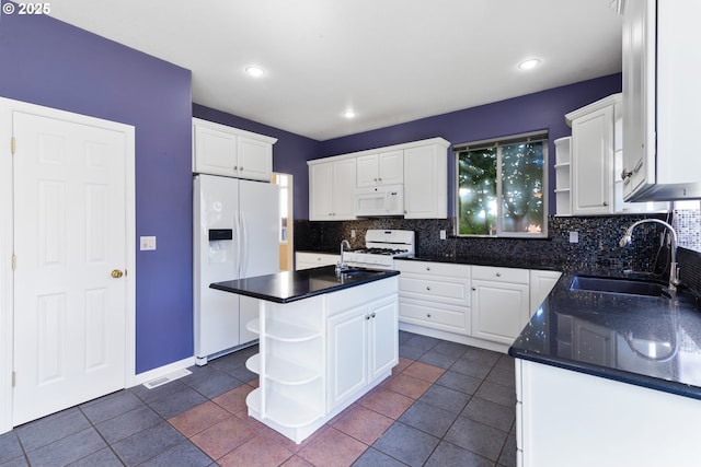 kitchen featuring open shelves, white appliances, dark countertops, and a sink