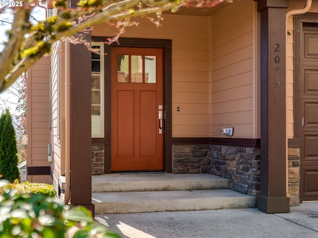 view of exterior entry featuring stone siding