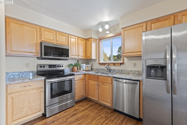 kitchen with sink, light brown cabinets, stainless steel appliances, and light stone countertops