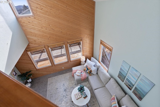 unfurnished living room with a high ceiling and wood walls