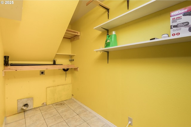 washroom with electric dryer hookup and light tile patterned floors