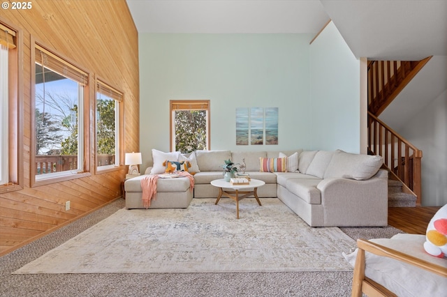 living room featuring a high ceiling and wood walls