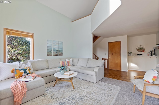 living room with high vaulted ceiling and light wood-type flooring