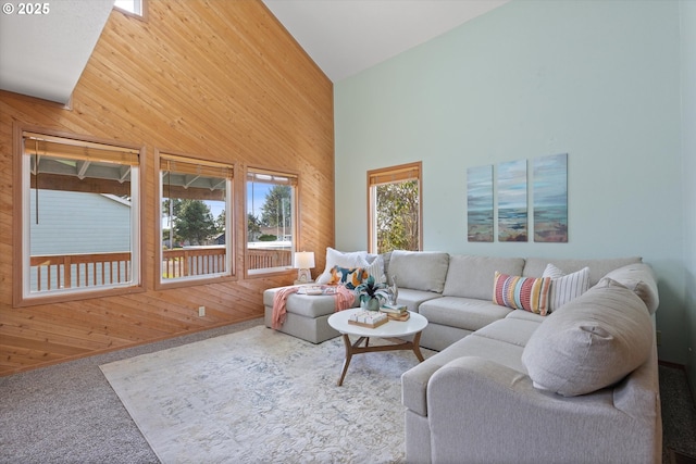 carpeted living room with high vaulted ceiling and wood walls