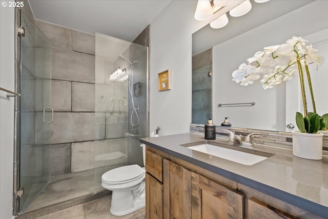 bathroom featuring tile patterned flooring, vanity, toilet, and an enclosed shower