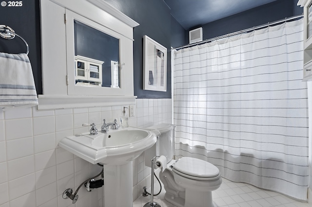2804 NE 61st Ave, Portland, OR 97213 - bathroom with toilet, tile walls, curtained shower, wainscoting, and tile patterned flooring