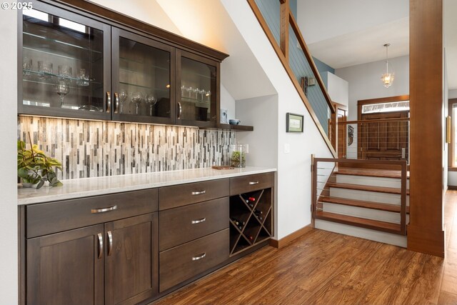 8866 Ocean Crest Ln, Manzanita, OR 97130 - bar area featuring stairs, wood finished floors, and decorative backsplash