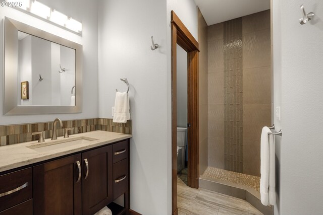 8866 Ocean Crest Ln, Manzanita, OR 97130 - bathroom with vanity, a tile shower, backsplash, and wood finished floors