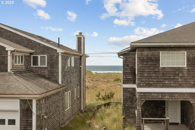8866 Ocean Crest Ln, Manzanita, OR 97130 - view of home's exterior featuring a chimney, view of water and beach, and a shingled roof