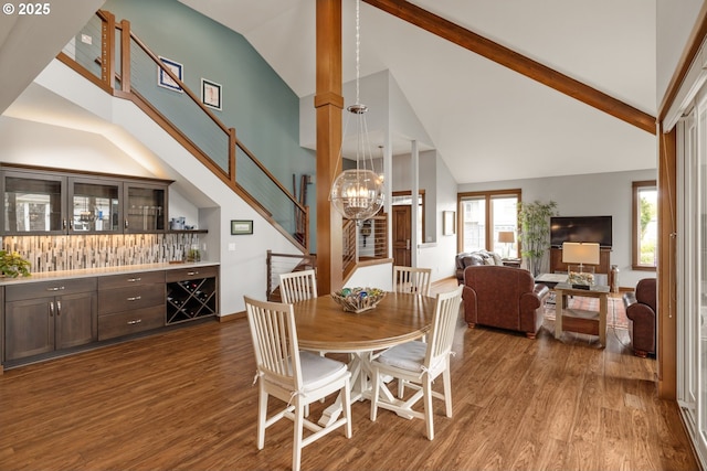 8866 Ocean Crest Ln, Manzanita, OR 97130 - dining space featuring wood finished floors, a chandelier, high vaulted ceiling, and stairs