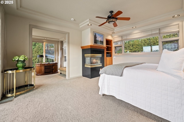 bedroom featuring ceiling fan, ornamental molding, carpet flooring, and a raised ceiling