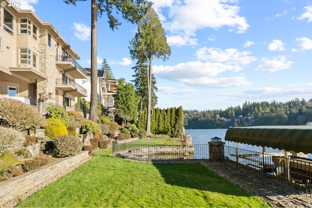 view of dock with a water view and a lawn