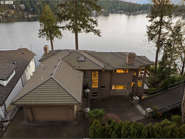 exterior space featuring a garage and a water view