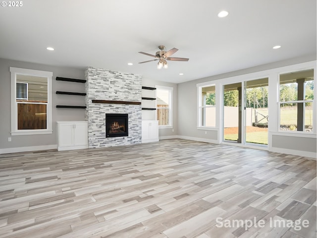 unfurnished living room with baseboards, light wood finished floors, recessed lighting, a tile fireplace, and ceiling fan