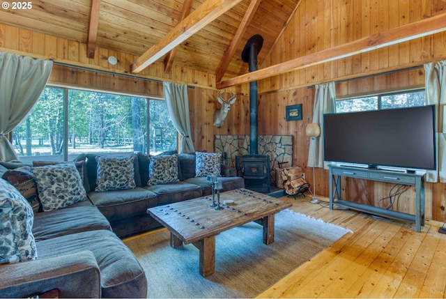 56095 Black Duck Rd, Bend, OR 97707 - living room with a wood stove, wood walls, wood-type flooring, wood ceiling with exposed beams, and high vaulted ceiling