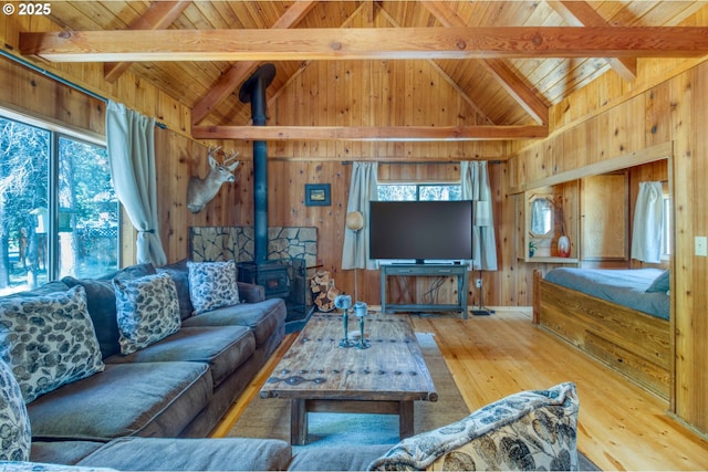 56095 Black Duck Rd, Bend, OR 97707 - living room with wooden ceiling, plenty of natural light, wood walls, wood-type flooring, and a wood stove