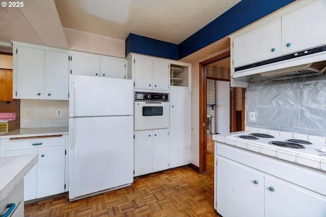 7450 SW Wilson Ave, Beaverton, OR 97008 - kitchen featuring white appliances, tile counters, under cabinet range hood, and white cabinetry