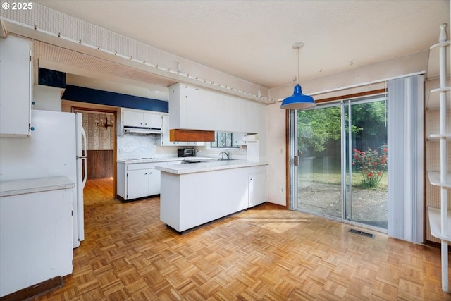 7450 SW Wilson Ave, Beaverton, OR 97008 - kitchen with a peninsula, light countertops, white cabinetry, pendant lighting, and under cabinet range hood