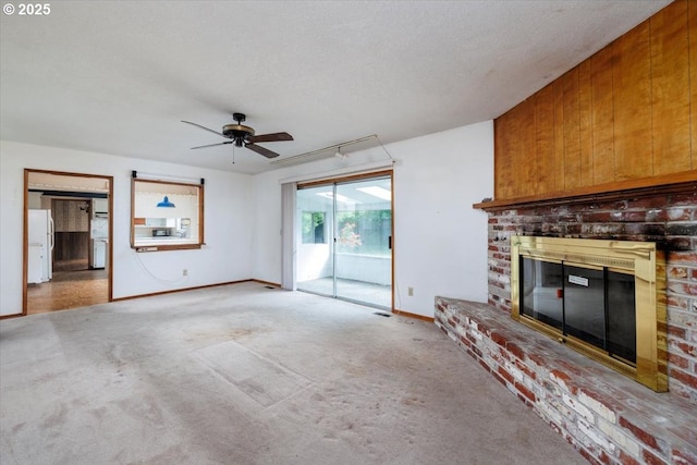 7450 SW Wilson Ave, Beaverton, OR 97008 - unfurnished living room featuring a brick fireplace, ceiling fan, carpet, and baseboards