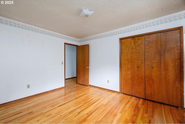 7450 SW Wilson Ave, Beaverton, OR 97008 - unfurnished bedroom with light wood-style floors, a closet, a textured ceiling, and baseboards