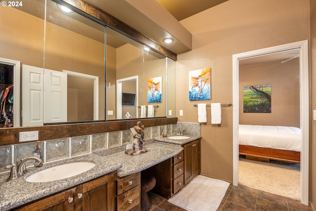 full bathroom with double vanity, ensuite bathroom, and a sink