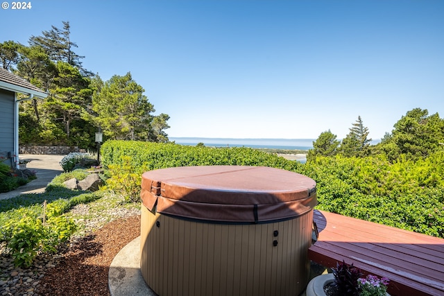 view of yard featuring a water view and a hot tub