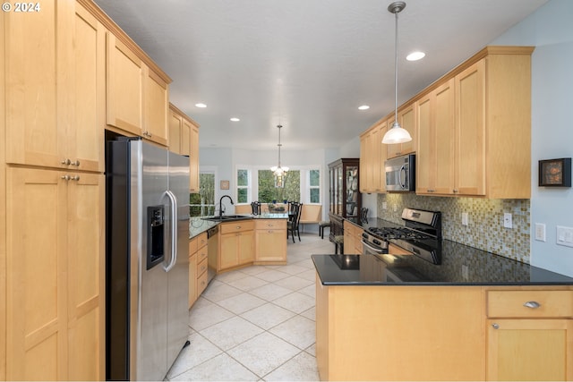 kitchen featuring stainless steel appliances, pendant lighting, light brown cabinets, and a peninsula