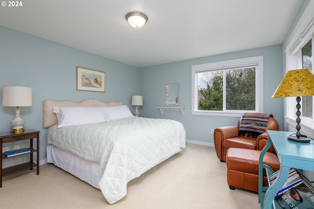 bedroom with light carpet and baseboards