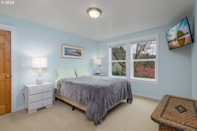 bedroom featuring baseboards and light colored carpet