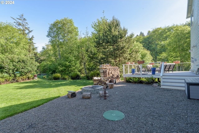 view of yard featuring a deck, a patio, and an outdoor fire pit