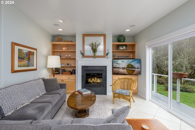 living area with a glass covered fireplace, recessed lighting, and light tile patterned floors