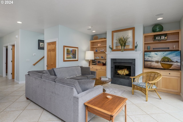 living area with light tile patterned floors, recessed lighting, baseboards, stairs, and a lit fireplace