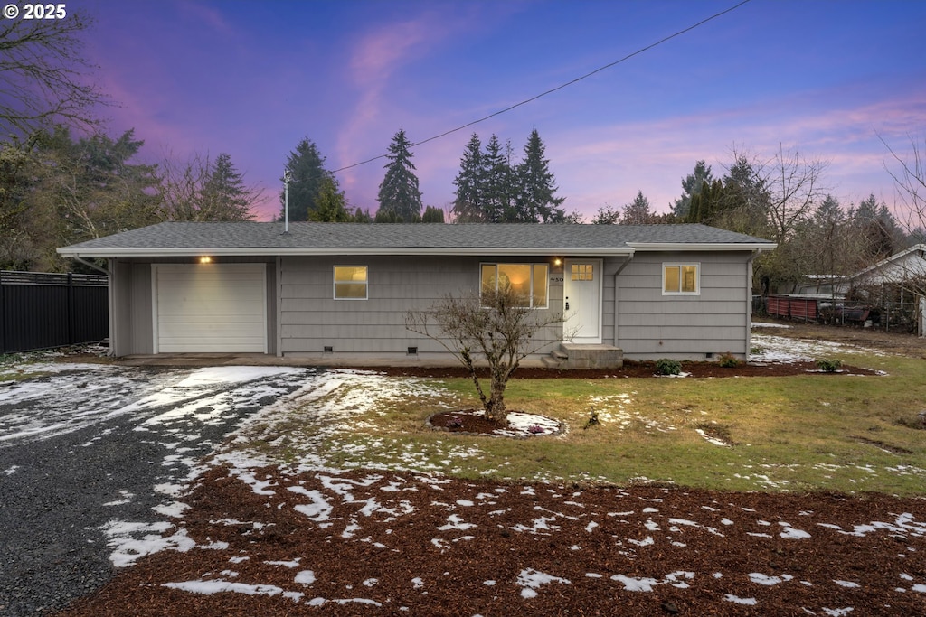 ranch-style home featuring a yard and a garage