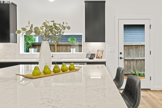 3528 NE 44th Ave, Portland, OR 97212 - kitchen with dark cabinetry, decorative backsplash, and light stone counters