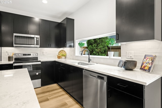 3528 NE 44th Ave, Portland, OR 97212 - kitchen with appliances with stainless steel finishes, dark cabinets, a sink, and decorative backsplash