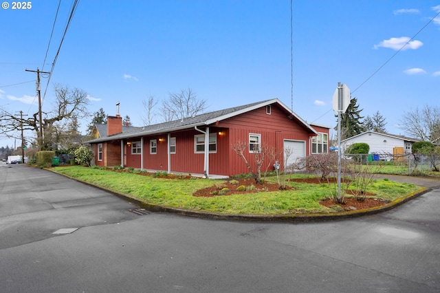 view of side of home featuring a chimney and fence