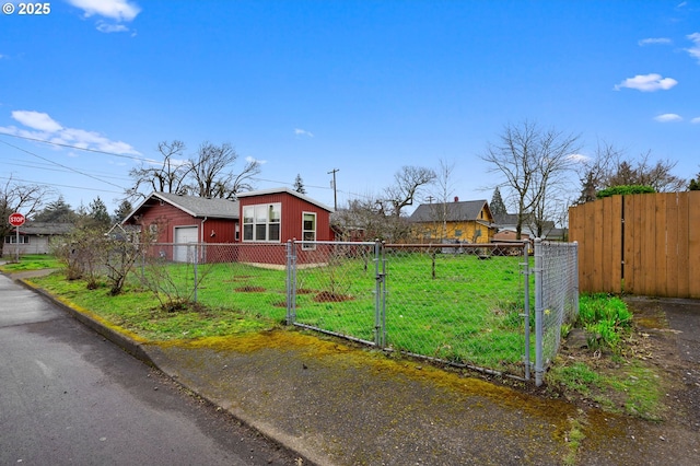 exterior space with a fenced front yard, a front lawn, and a gate