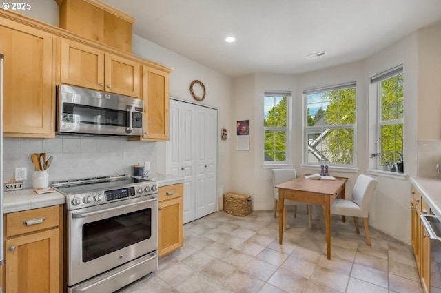 6395 Summerlinn Way W, Linn, OR 97068 - kitchen featuring appliances with stainless steel finishes, light countertops, decorative backsplash, recessed lighting, and light brown cabinetry