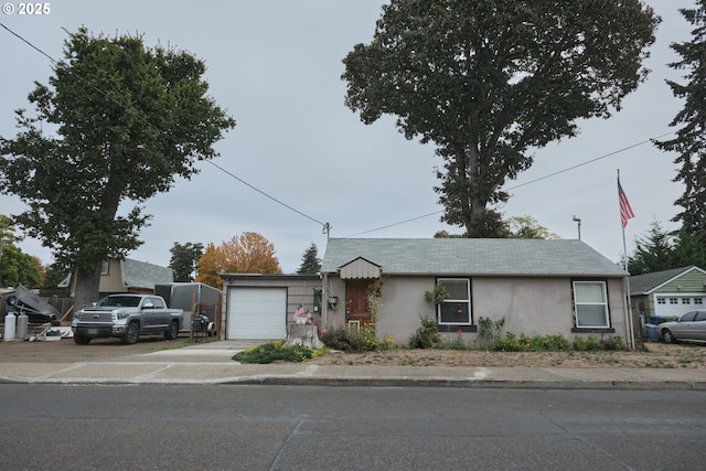 ranch-style house with an attached garage, driveway, and stucco siding