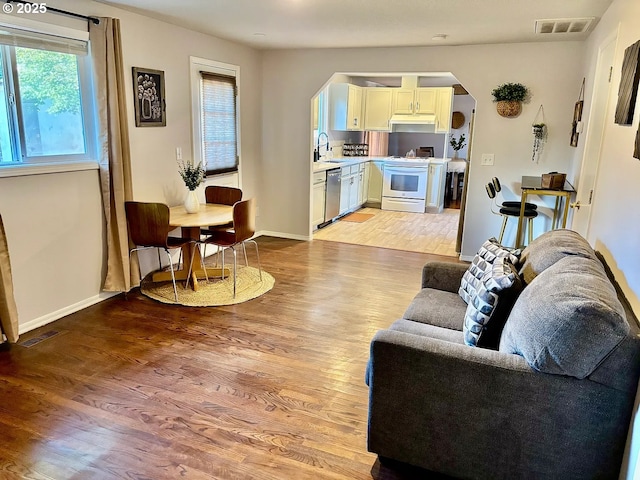 12708 NE 46th St, Vancouver, WA 98662 - living room with arched walkways, light wood-type flooring, and plenty of natural light