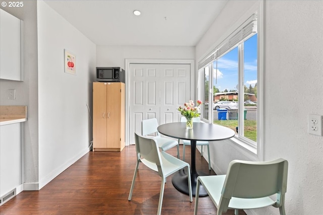 dining area with baseboards, dark wood finished floors, a wealth of natural light, and visible vents