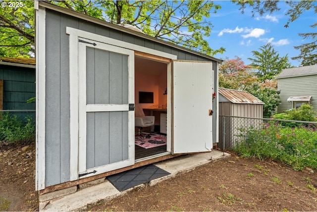 view of shed featuring fence