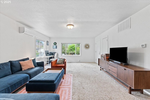 living area with a textured ceiling, visible vents, light carpet, and a wall mounted AC