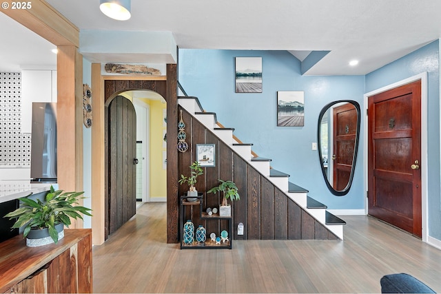 1090 Maple Dr, Eugene, OR 97404 - entryway with arched walkways, wood finished floors, stairway, and baseboards