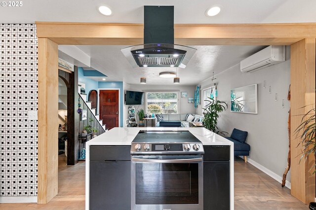 1090 Maple Dr, Eugene, OR 97404 - kitchen with electric range, a wall unit AC, island exhaust hood, baseboards, and light countertops