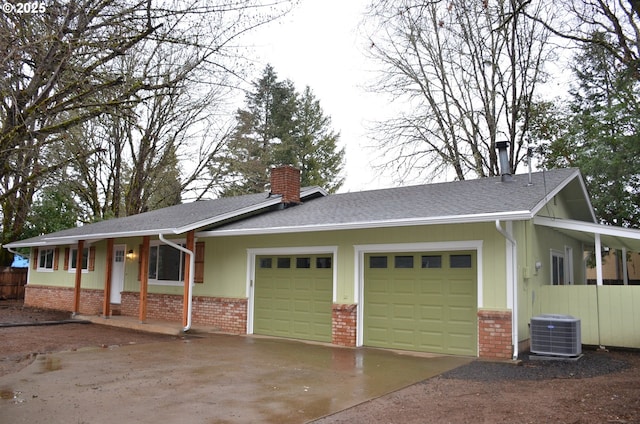 view of front of house with central air condition unit and a garage