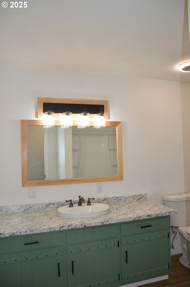 bathroom with hardwood / wood-style floors, vanity, and toilet