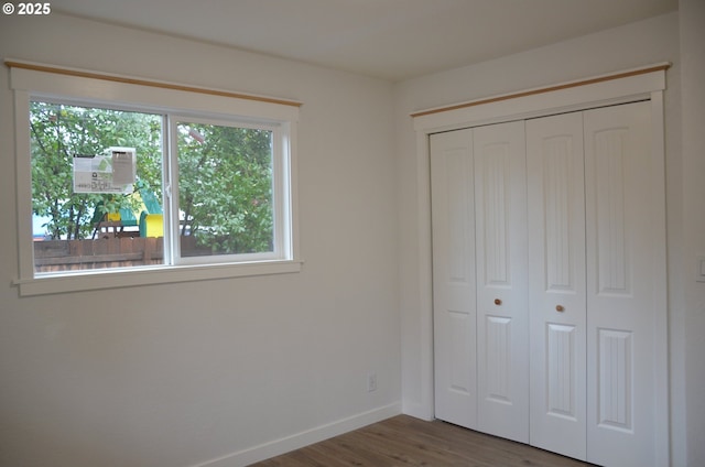 unfurnished bedroom featuring a closet and dark wood-type flooring