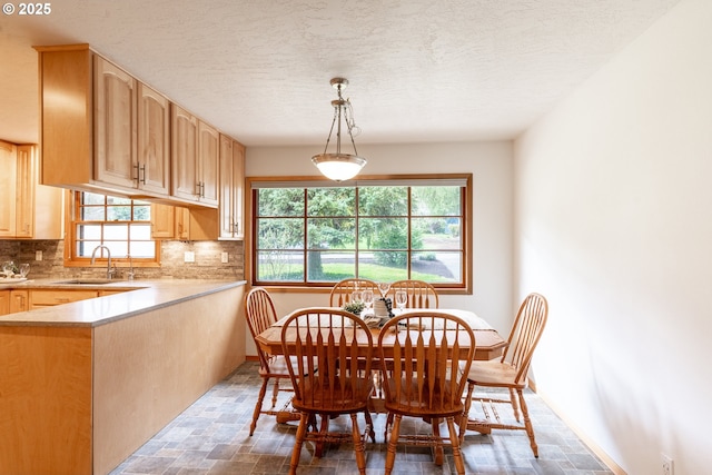 dining space featuring stone finish floor, a textured ceiling, and baseboards