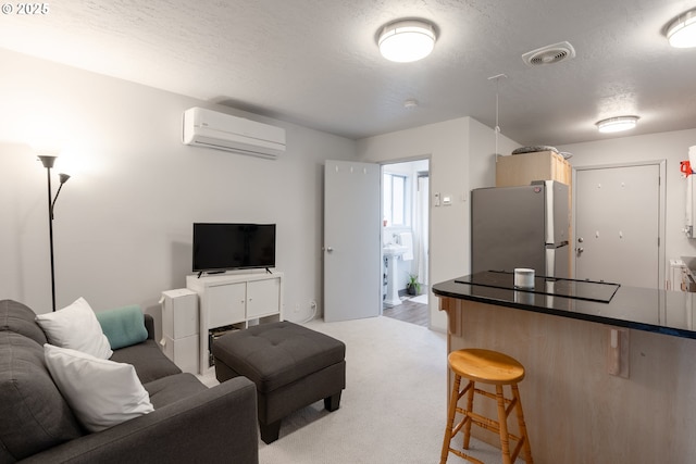 living area featuring an AC wall unit, light carpet, visible vents, and a textured ceiling